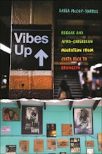 Vibes Up On the top is a New York subway station sign. The bottom is a wall covered in framed newspaper clippings and photos of famous Black figures.